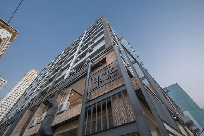 The Grid Co-living seen from Yakal Street, looking up the corner of the building past its signage